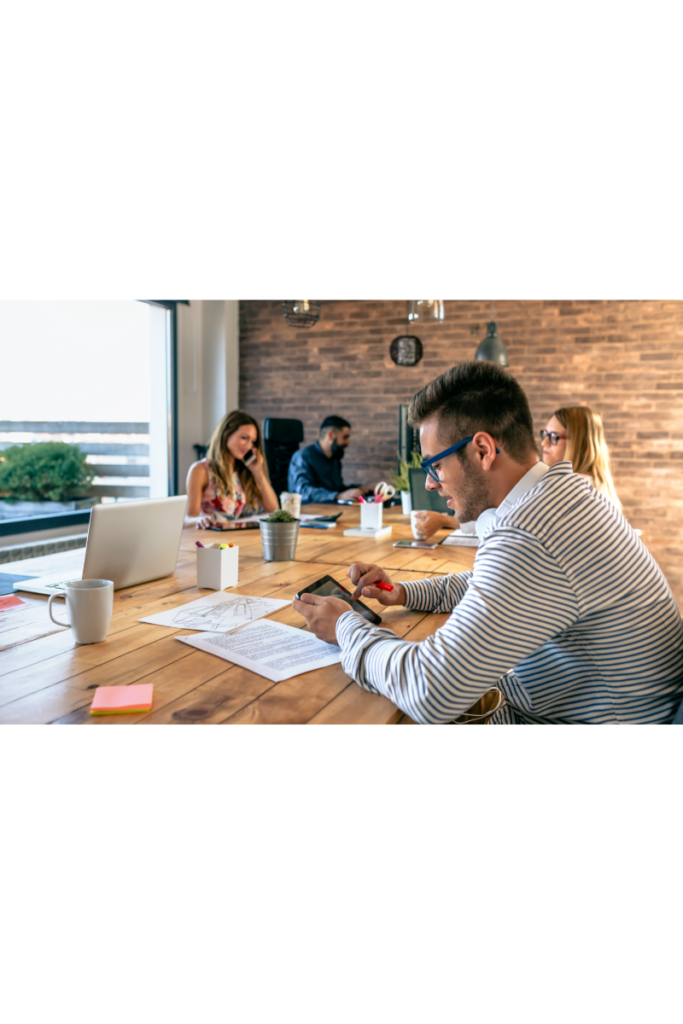 En grupp av yrkesverksamma arbetar tillsammans i ett öppet och inspirerande coworking-utrymme